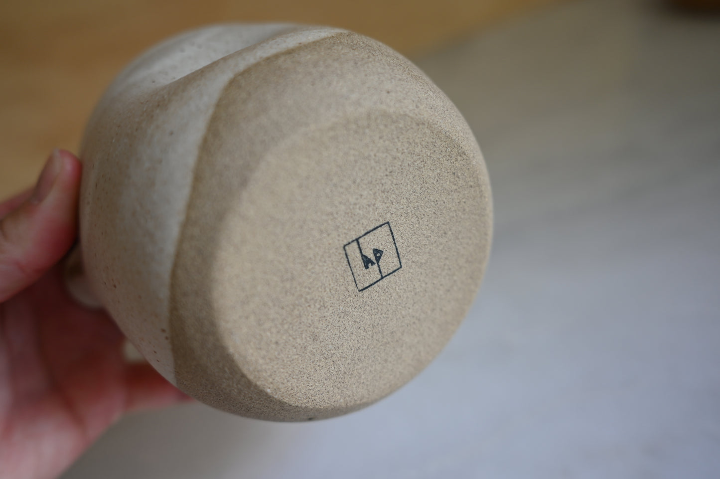 Person holding Matcha bowl showing the bottom of the bowl with brand stamp