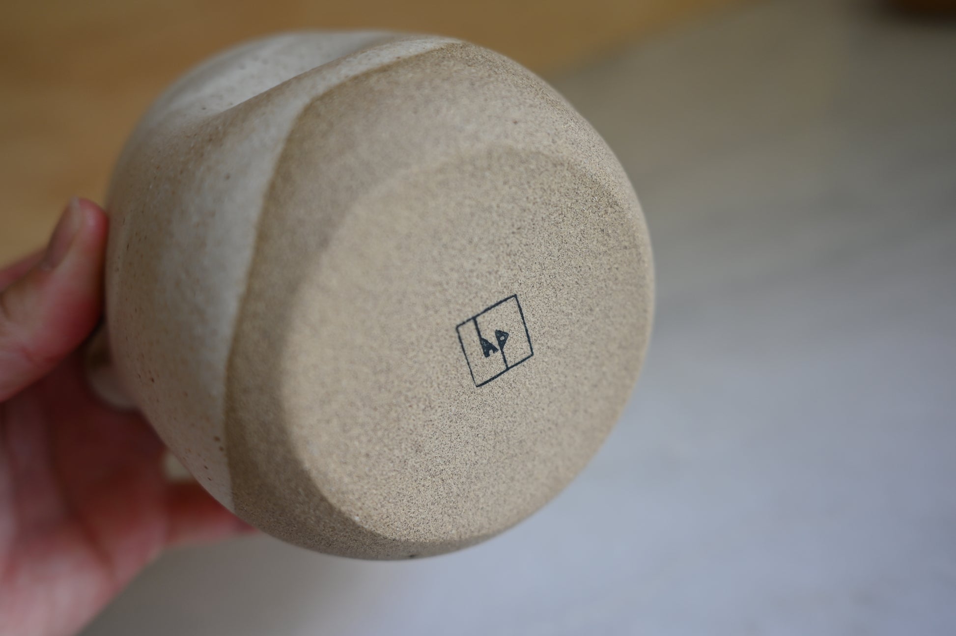 Person holding Matcha bowl showing the bottom of the bowl with brand stamp
